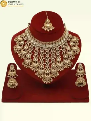Antique gold bridal necklace set with hanging beads, matching jhumka earrings, and maangtika on red display stand, Ishwar Arts and Crafts