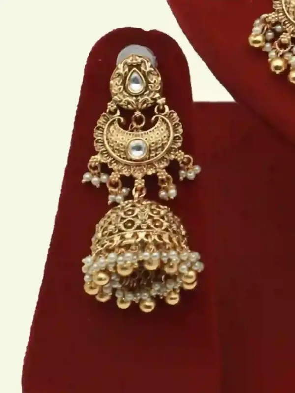 Antique gold bridal necklace set with hanging beads, matching jhumka earrings, and maangtika on red display stand, Ishwar Arts and Crafts